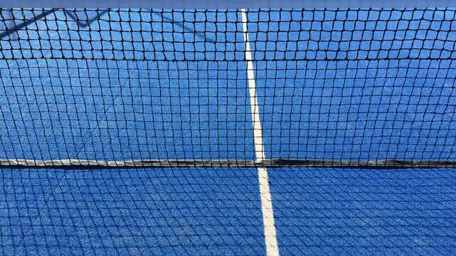 Padel tennis. A close up view of blue netting stretched tautly across a frame providing a pattern backdrop for photography or design projects, perfect for capturing depth