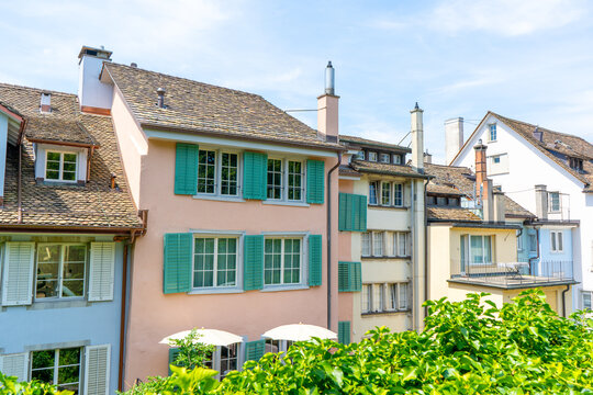 European Houses with Tiled Roofs, Dormer Windows and Lush Green. Old city architecture. Window with wooden shutters. Cityscape in Zurich Switzerland.