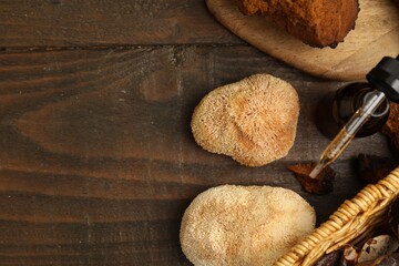 Fototapeta premium Functional mushrooms and bottle of oil on wooden table, flat lay. Space for text