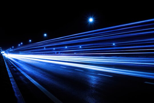Blue light trails on a wet highway at night during long exposure showing speed and motion