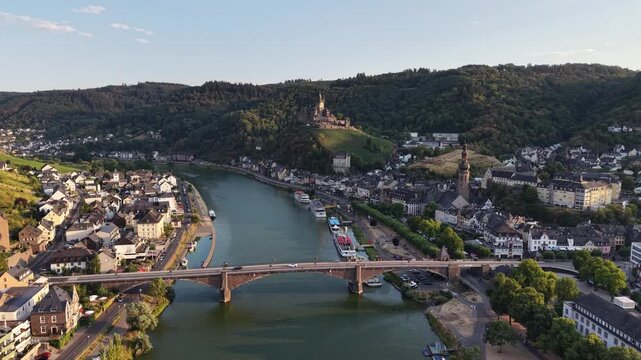 Aerial drone view of Cochem on the Moselle River, Germany, with the historic Reichsburg Cochem castle overlooking the old town, bridge and riverfront. Scenic summer landscape in the Moselle Valley.