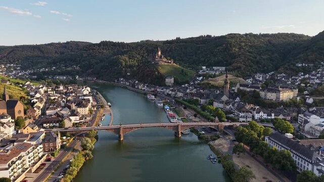 Aerial drone view of Cochem on the Moselle River, Germany, with the historic Reichsburg Cochem castle overlooking the old town, bridge and riverfront. Scenic summer landscape in the Moselle Valley.