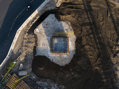 Aerial view of the construction of the Solo-Yogyakarta Toll Road showing a concrete foundation pillar base and excavated earth in Kecamatan Depok, Daerah Istimewa Yogya, Indonesia.