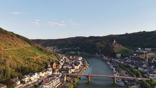 Aerial drone view of Cochem on the Moselle River, Germany, with the historic Reichsburg Cochem castle overlooking the old town, bridge and riverfront. Scenic summer landscape in the Moselle Valley.