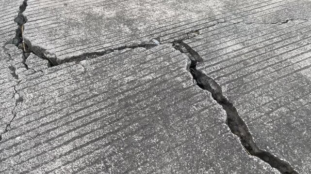 Close Up Texture of Cracked and Damaged Concrete Road