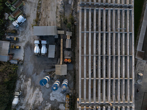 Aerial view of the construction of the Solo-Yogyakarta Toll Road featuring concrete beams and cement mixers at the site in Kecamatan Depok, Daerah Istimewa Yogya, Indonesia.