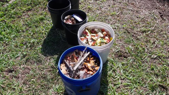 Buckets filled with organic waste ready for community composting windrow pile