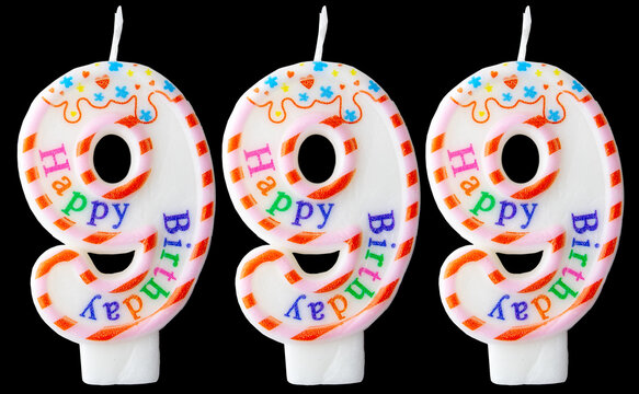 Number nine hundred ninety-nine shaped birthday candles with colorful sprinkles and Happy Birthday text isolated on a black background