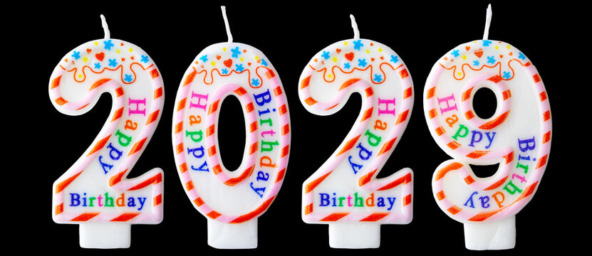 Number two thousand twenty-nine shaped birthday candles with colorful sprinkles and Happy Birthday text isolated on a black background