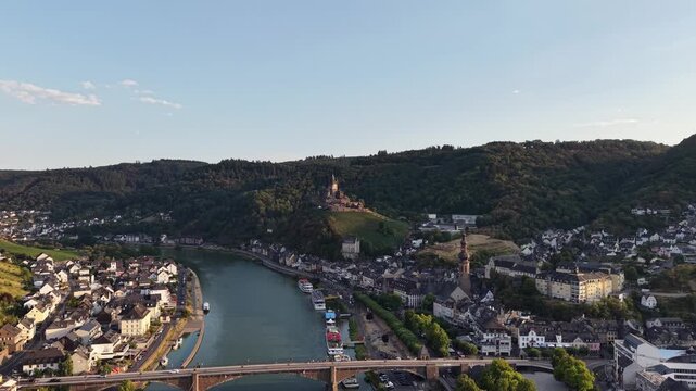 Aerial drone view of Cochem on the Moselle River, Germany, with the historic Reichsburg Cochem castle overlooking the old town, bridge and riverfront. Scenic summer landscape in the Moselle Valley.