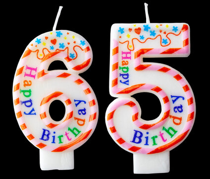 Number sixty five shaped birthday candle with colorful sprinkles and Happy Birthday text isolated on a black background