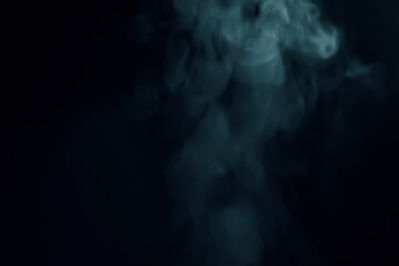 Naklejka premium Abstract blue smoke vapor swirling against a dark black background