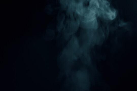 Abstract blue smoke vapor swirling against a dark black background