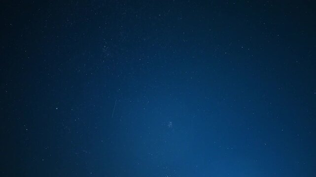 night timelapse of starry space with perseid meteors on blue background
