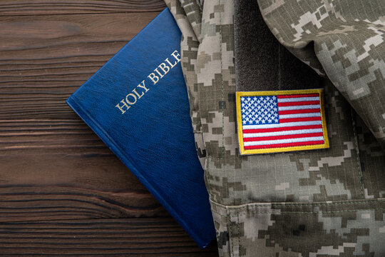 Holy Bible beside military camouflage uniform with American flag, concept of military chaplaincy US, faith and spiritual support