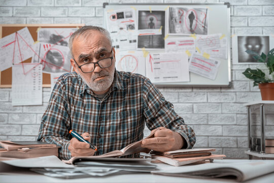 and taking notes in front of a board covered with clues, and mysterious images in the background. Concept of conspiracy theories, belief in UFOs