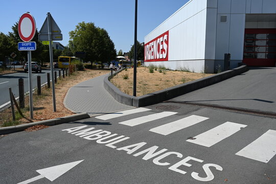 signal&eacute;tique pour l'entr&eacute;e des ambulances &agrave; l'h&ocirc;pital. Panneau routier et lettres blanches peintes sur la route en goudron. Au fond le mot Urgences est peint sur un mur blanc avec un fond rouge vif