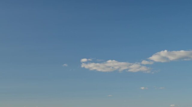 timelapse of sparse cloud bands floating in the blue sky