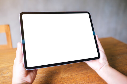 Mockup image of a woman holding digital tablet with blank white desktop screen