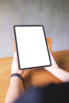 Vertical mockup image of a woman holding digital tablet with blank white desktop screen