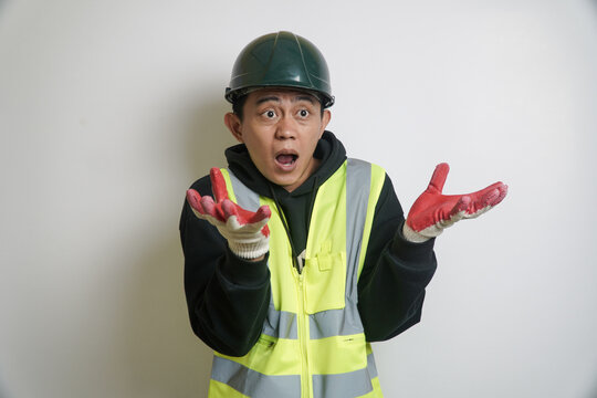 Shocked Asian Construction Worker in Safety Vest and Hard Hat with Hands Up
