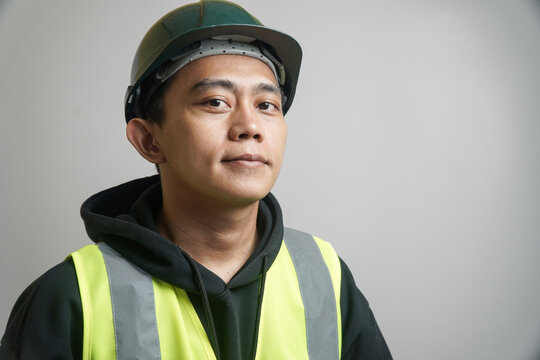 Portrait of a Focused Young Man Wearing a Safety Hard Hat and Reflective Vest
