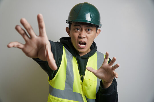 Alarmed Worker in Hard Hat and Safety Vest Stretching Hands Out
