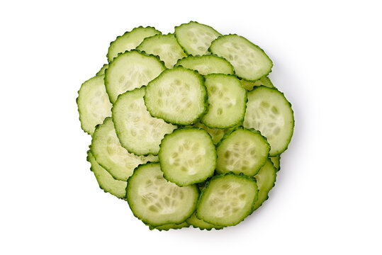 Circular arrangement of thin cucumber slices on clean white surface, showing fresh green rings, translucent centers, textured rinds, and bright studio lighting with minimal styling