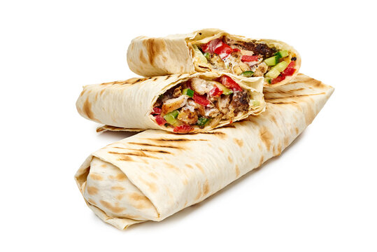 Grilled tortilla wrap halves filled with seasoned minced meat, chopped tomatoes, shredded lettuce, sliced onions and creamy sauce, stacked on white background with warm golden grill marks