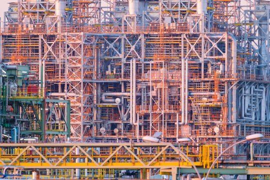 Industrial pipes and equipment at an oil refinery plant. Heavy manufacturing infrastructure for petroleum production.