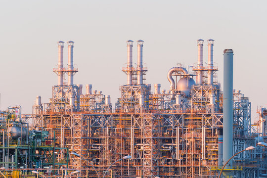 Industrial pipes and equipment at an oil refinery plant. Heavy manufacturing infrastructure for petroleum production.