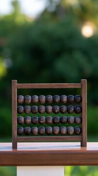 Vintage wooden abacus with weathered dark beads on a railing, symbolizing traditional calculation and learning