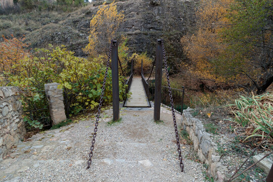 Suspension bridge crossing a scenic forest path in autumn