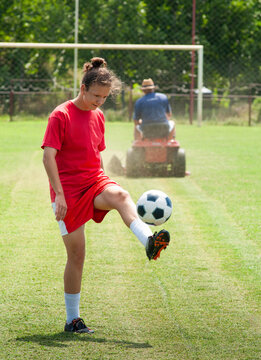 Female Soccer Player Controlling Ball on Grass Field