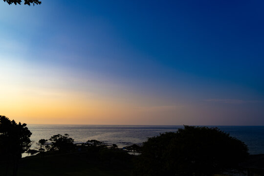 Horizon marin paisible au cr&eacute;puscule sous un ciel bleu profond et une lueur chaude