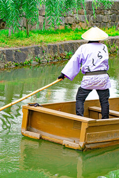 Batelier traditionnel dirigeant une barque sur le canal de Kurashiki, Okayama, Japon