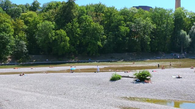 Menschen erfrischen sich am Ufer der k&uuml;hlen Isar an einem hei&szlig;en Sommertag, M&uuml;nchen, Oberbayern, Bayern, Deutschland