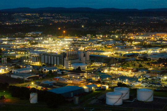 Aerial view of the industrial area in Inverness at night, featuring illuminated warehouses, storage tanks, and factory buildings in Inverness, Scotland, United Kingdom.