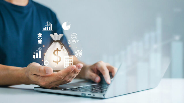 Businessman working on a laptop with a virtual money bag icon, financial growth and investment concept