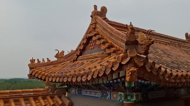 Traditional Chinese pavilion roof fragment with yellow glazed tiles stands under a cloudy sky outdoors. Asian tourism, historical landmarks, summer palace Beijing.