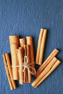 Cinnamon sticks on black table. Flat lay, copy space