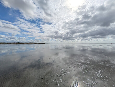 Wolkenspiegelungen im nassen Watt bei Ebbe in H&ouml;he Cuxhaven Sahlenburg Niedersachen