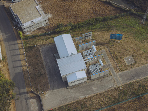 Aerial view of the Subestacao E-Redes Gondomar electrical substation featuring transformers and metal fencing surrounded by dry grass in Sao Cosme, Porto District, Portugal.