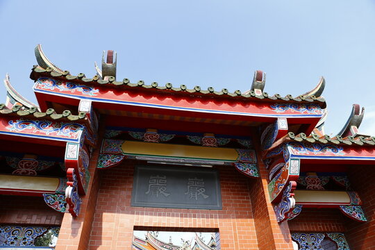 Traditional Chinese temple roof architecture against a blue sky.