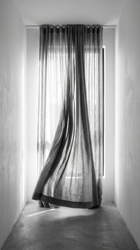 Elegant Sheer Curtain Flowing Gently By A Large Window