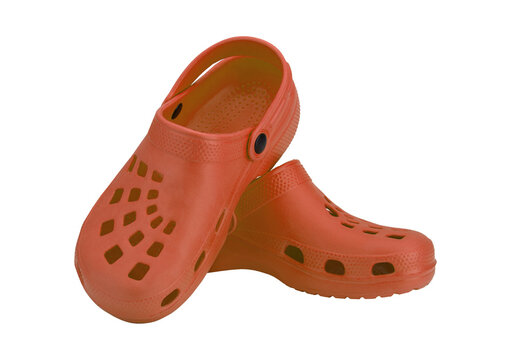 Pair of orange crocs for comfortable summer footwear with holes.