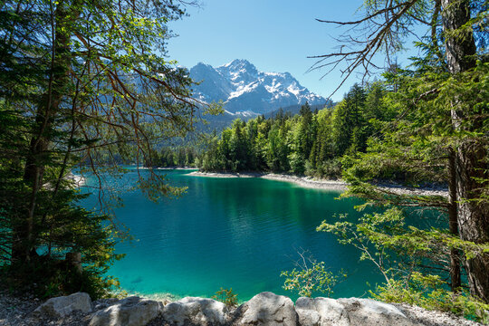 Travel landscape of Zugspitze Alps in Bavaria, Germany, scenic summer nature panorama with forest, Eibsee lake, snow mountains peak. Alpine landscape