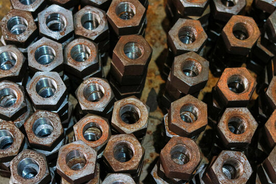 Top View of Stacked Heavy Hexagonal Metal Nuts and Threaded Fasteners