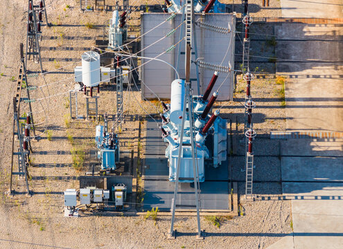 Aerial view of a high voltage power transformer and electrical equipment at an electricity substation with insulators and transmission infrastructure in Saulce-sur-Rhone, France.