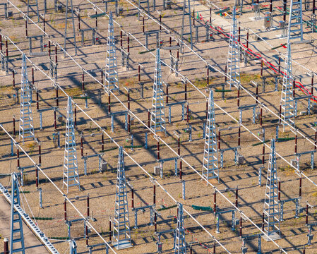 Aerial view of a high voltage electrical substation with a complex network of power lines, insulators, busbars, and steel support structures in Saulce-sur-Rhone, Auvergne-Rhone-Alpes, France.